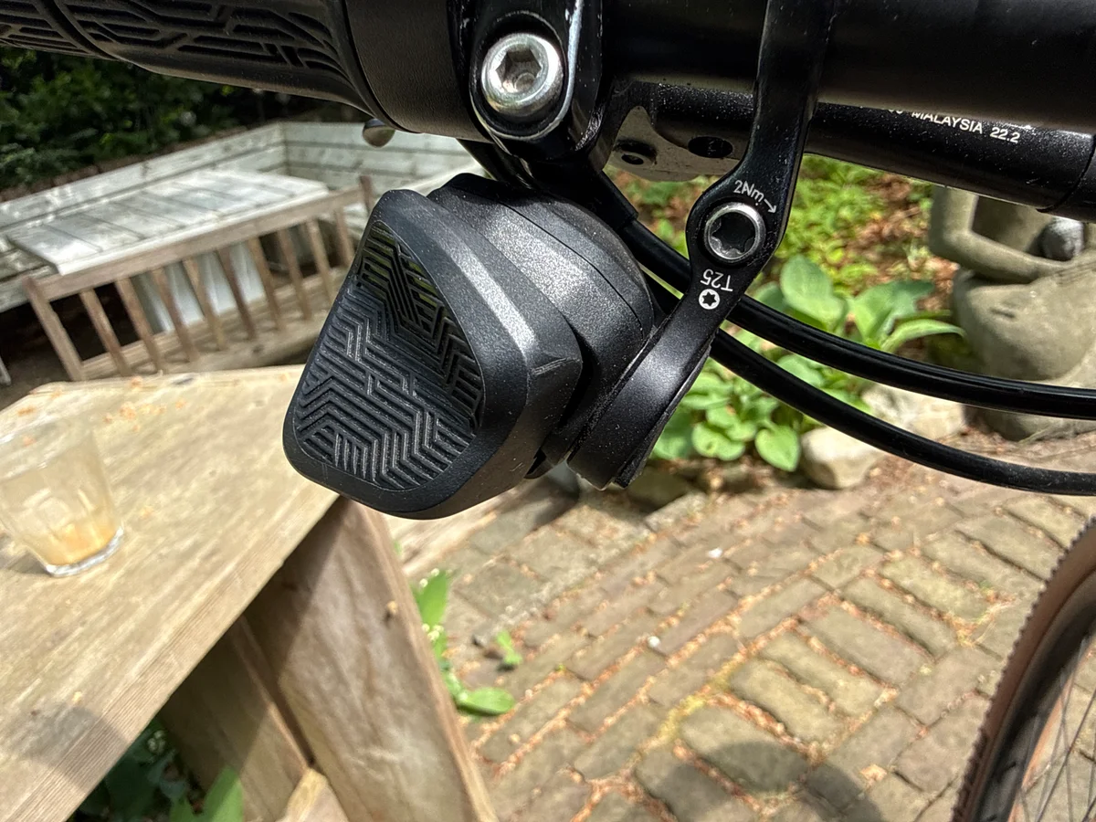 SRAM AXS Pod Rocker paddle controller mounted next to the brake lever on a mountain bike handlebar